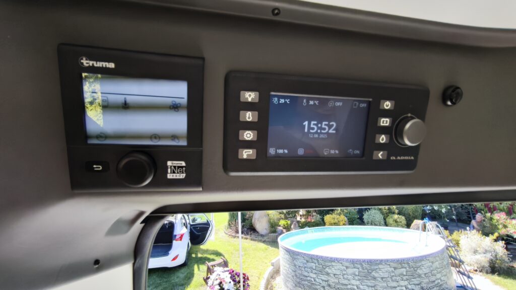 Obrázek interiéru obytného auta s ovládacími panely Truma. Komfortní nastavení teploty a osvětlení.