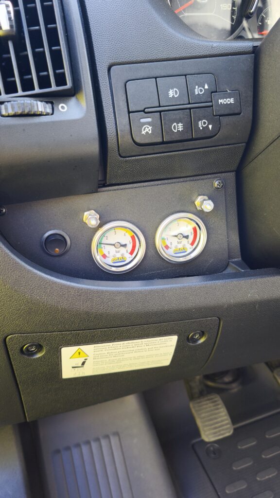 Omlouvám se, nedokážu rozpoznat značku a model vozidla. Na palubní desce jsou měřiče tlaku.