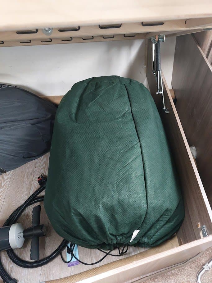 Obrázek zobrazuje úložný prostor s vakuovým pytlem a příslušenstvím, ideální pro vybavení obytného vozu.