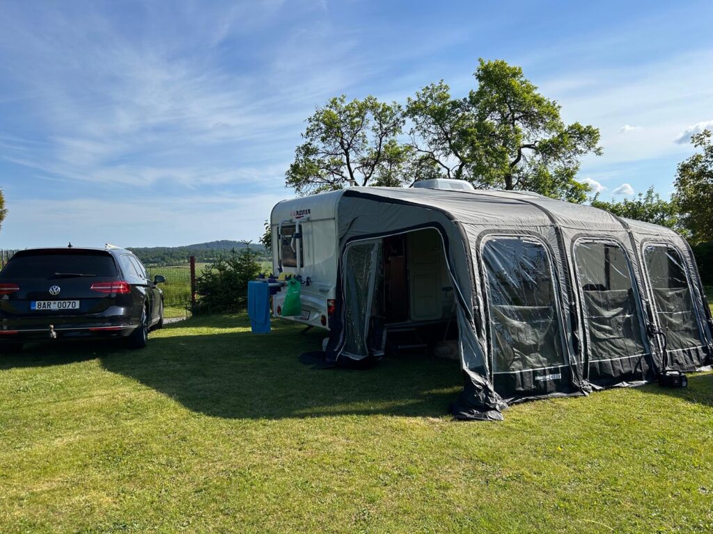 Na obrázku je karavan Lander s připojeným automobilem Volkswagen. Ideální pro letní dobrodružství!