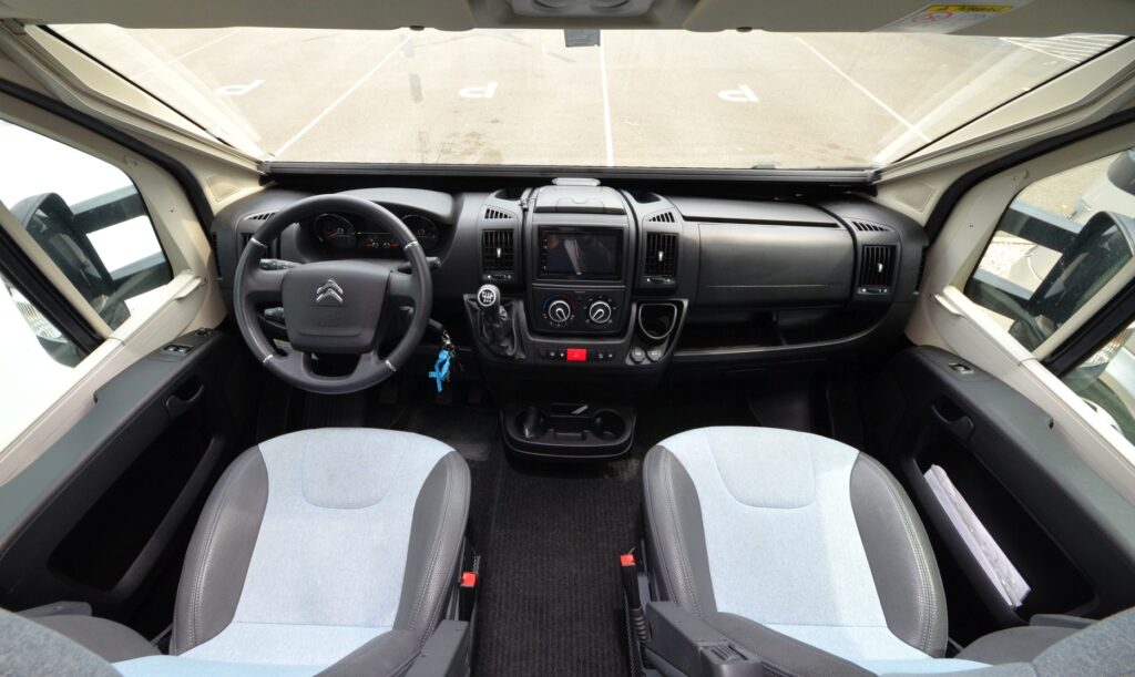Interiér obytného auta Citroën s pohodlnými sedadly a moderními ovládacími prvky. Ideální pro cestování.