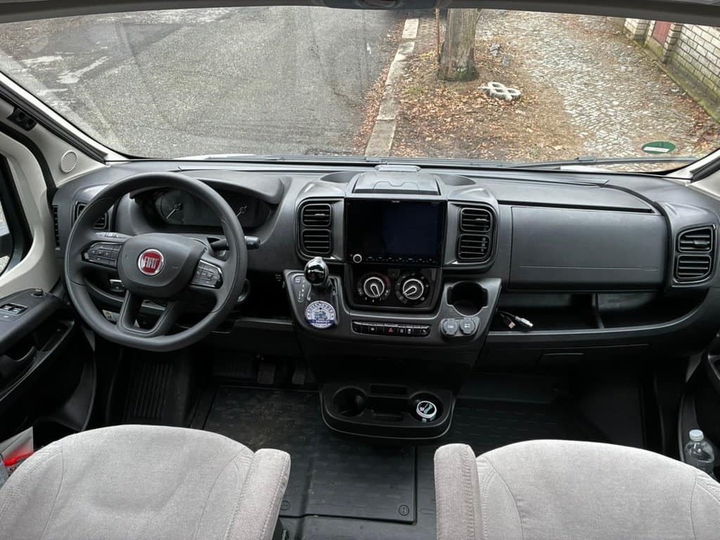 Interiér obytného auta Fiat, moderní design s pohodlným ovládáním a dostatkem úložného prostoru pro cestování.