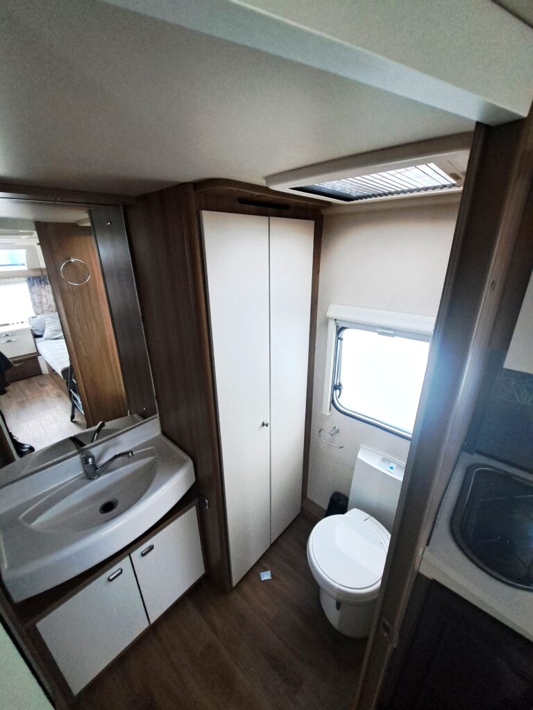 Interiér karavanu s koupelnou a toaletou. Moderní design, prostorné uspořádání.