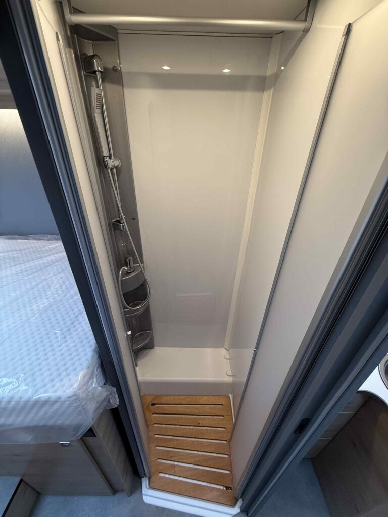 Obrázek ukazuje moderní sprchu v obytném voze, ideální pro pohodlné cestování.