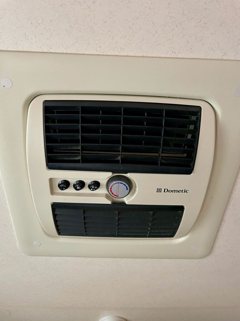 Obrázek ukazuje klimatizaci Dometic, která je součástí obytného vozu pro pohodlné cestování.