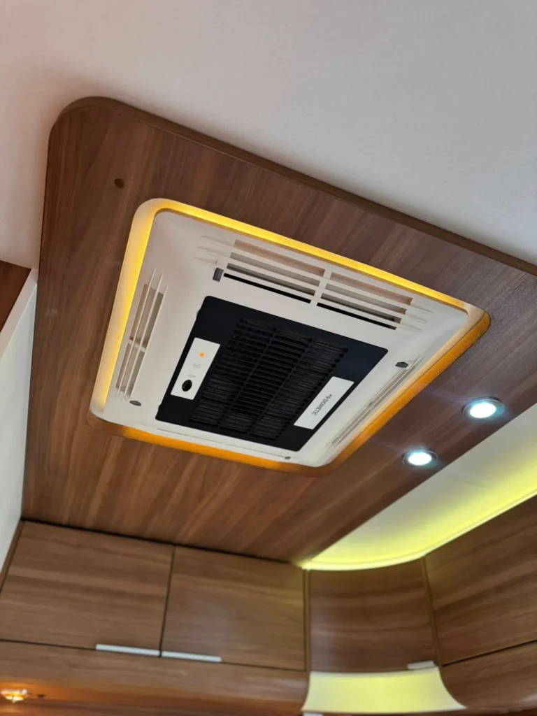 Obrázek ukazuje klimatizaci v interiéru obytného auta, který poskytuje pohodlí při cestování.