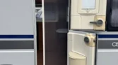 Obrázek zobrazuje karavan Ascaris s bočními dveřmi a výhledem na interiér. Ideální pro pohodlné cestování!
