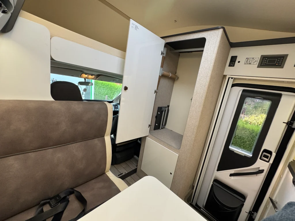 Obrázek interiéru obytného auta s moderním designem a praktickými úložnými prostory.