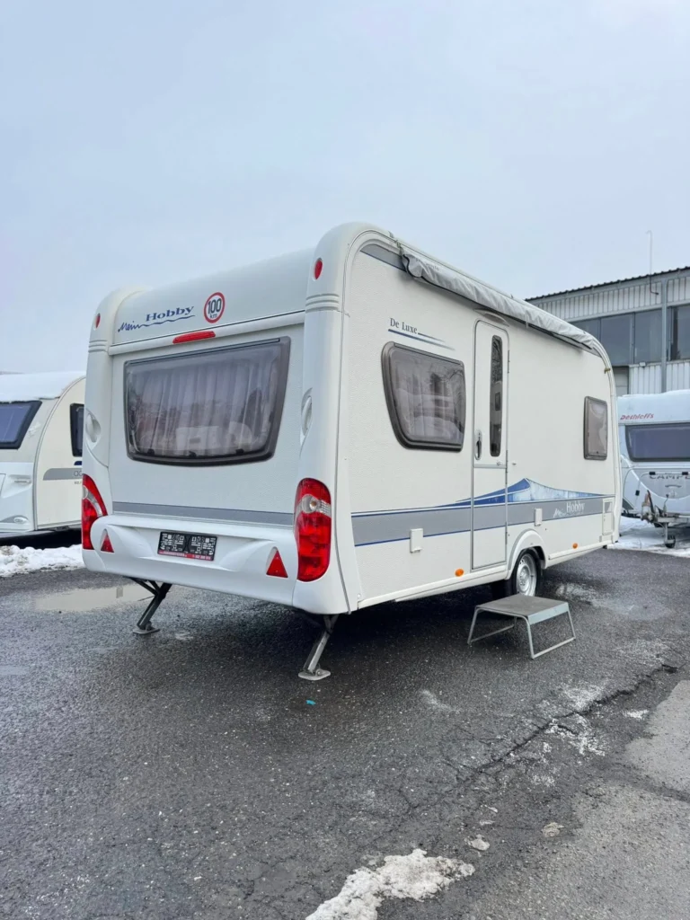Karavan Hobby De Luxe, ideální pro pohodlné cestování a kempování v krásné přírodě.
