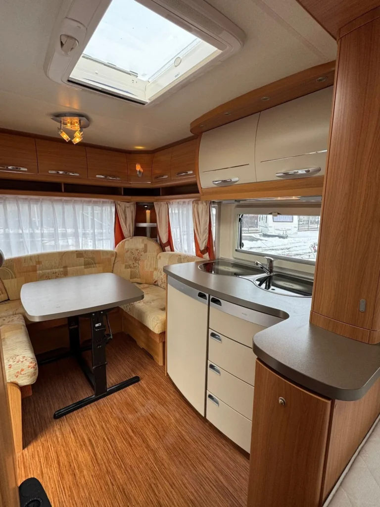 Karavan s moderním interiérem, pohodlným posezením a kuchyňkou. Ideální pro cestování a dobrodružství.