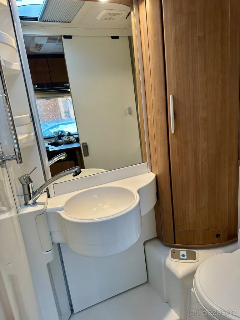 Obrázek interiéru obytného auta s koupelnou a moderním designem. Ideální pro pohodlné cestování.