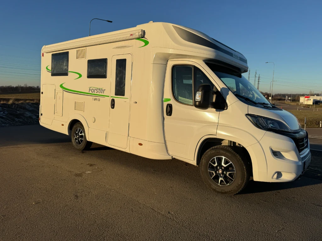 Obytné auto Forster T 699 EB na slunné cestě, ideální pro dobrodružství na cestách.