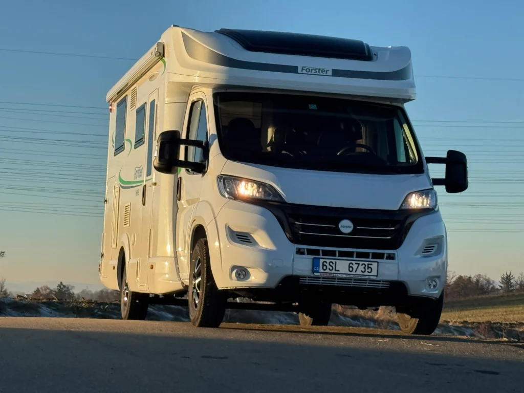 Obytné auto Forster na silnici, ideální pro dobrodružství v přírodě. Elegantní design a pohodlný interiér.