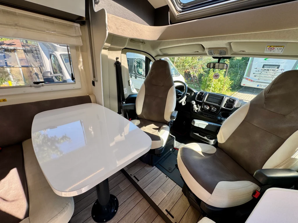 Obytné auto s pohodlným interiérem a stolkem, ideální pro cestování a relaxaci.