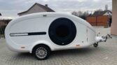 Moderní karavan AYAZ s aerodynamickým designem vhodný pro pohodlné cestování a kempování.
