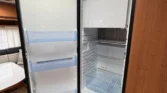 Obrázek interiéru karavanu s lednicí Dometic. Moderní a praktické uspořádání pro pohodlné cestování.