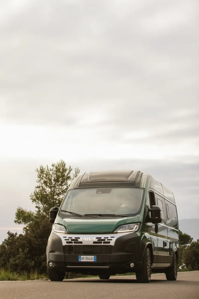 Laika obyté auto na silnici, připravené na dobrodružství, obklopené přírodou a krásným počasím.