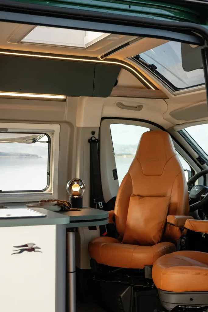 Interiér obytného auta s koženými sedadly a moderním designem. Neznámá značka a model.