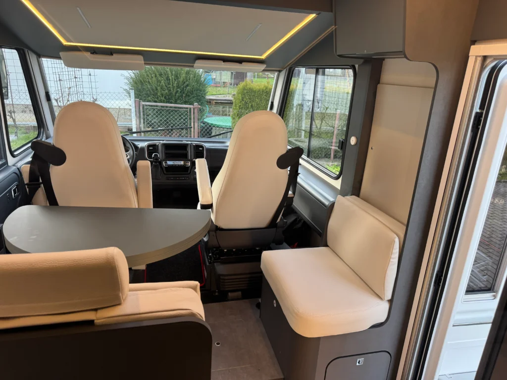 Interiér obytného auta s moderním designem a pohodlným sezením. Ideální pro cestování a relaxaci.