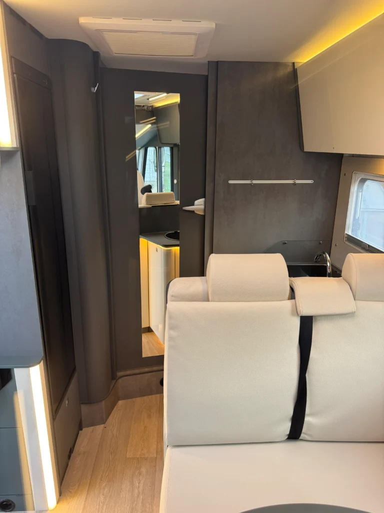 Moderní interiér obytného auta s elegantním designem a praktickým uspořádáním.