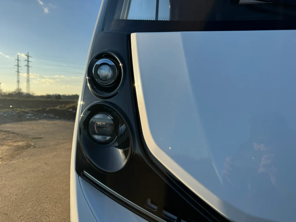 Na obrázku je detail přední části obytného auta, bohužel značka a model nejsou viditelné.