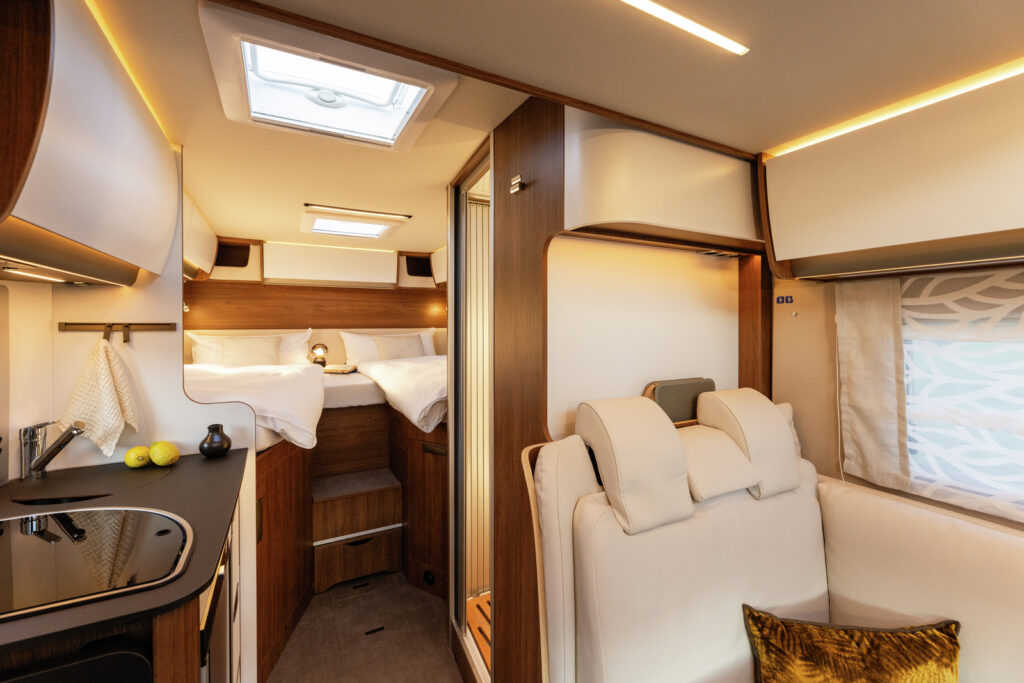 Obrázek interiéru karavanu s moderním designem a pohodlnými lůžky. Ideální pro cestování a odpočinek.