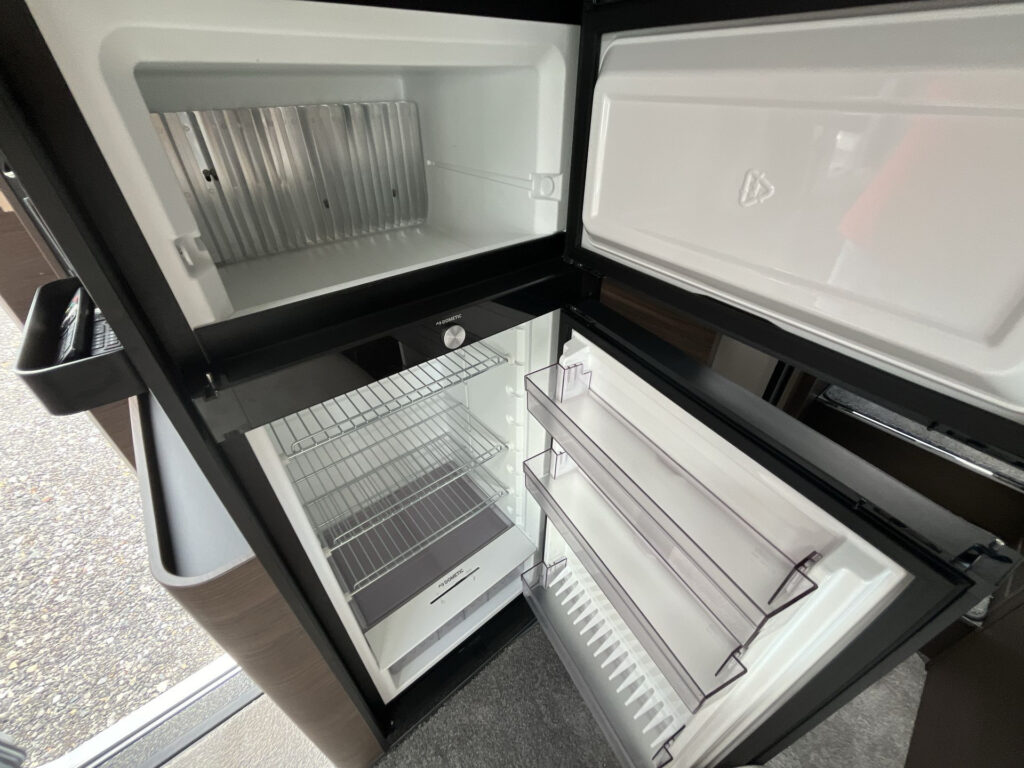 Obrázek zobrazuje interiér chladničky v obytném voze. Ideální pro uchovávání potravin na cestách.