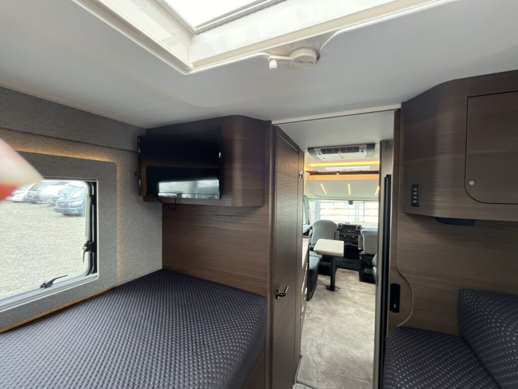 Obrázek interiéru obytného auta s moderním designem a vybavením. Značku a model nelze určit.