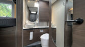 Obrázek interiéru obytného auta s moderní koupelnou. Elegantní design a funkčnost pro cestování.