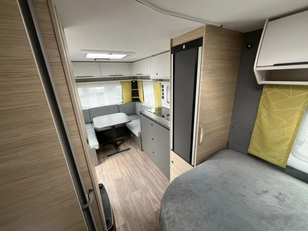 Obrázek interiéru karavanu s moderním uspořádáním a komfortním posezením.