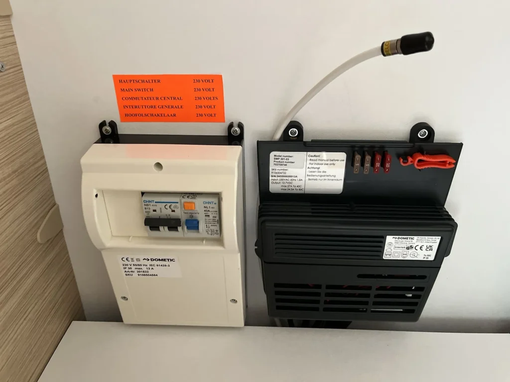 Obrázek zobrazuje elektrickou skříňku Dometic pro obytné auto. Obsahuje jističe a pojistky pro správnou funkci.