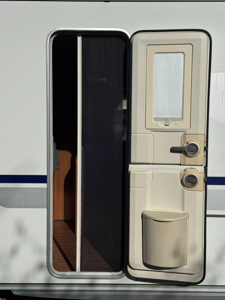 Obrázek ukazuje dveře obytného auta s moderním designem a prostorným vstupem.