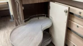Obrázek interiéru karavanu s praktickým úložným prostorem v moderním designu. Ideální pro pohodlné bydlení na cestách.