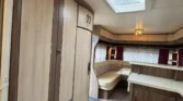 Toto je interiér karavanu s moderním designem a prostornou kuchyňkou. Vhodný pro pohodlné cestování.