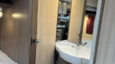 Obrázek interiéru karavanu, moderní zařízení a útulný design, ideální pro pohodlné cestování.