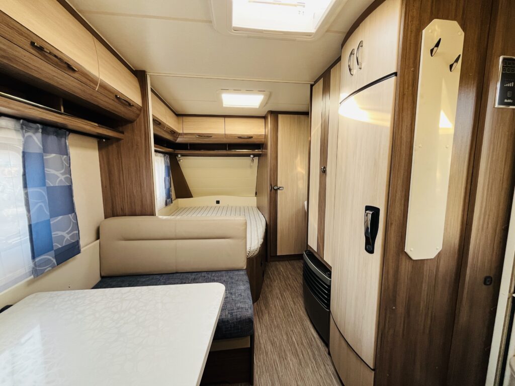 Obrázek interiéru karavanu s moderním designem a komfortním uspořádáním. Ideální pro cestování.