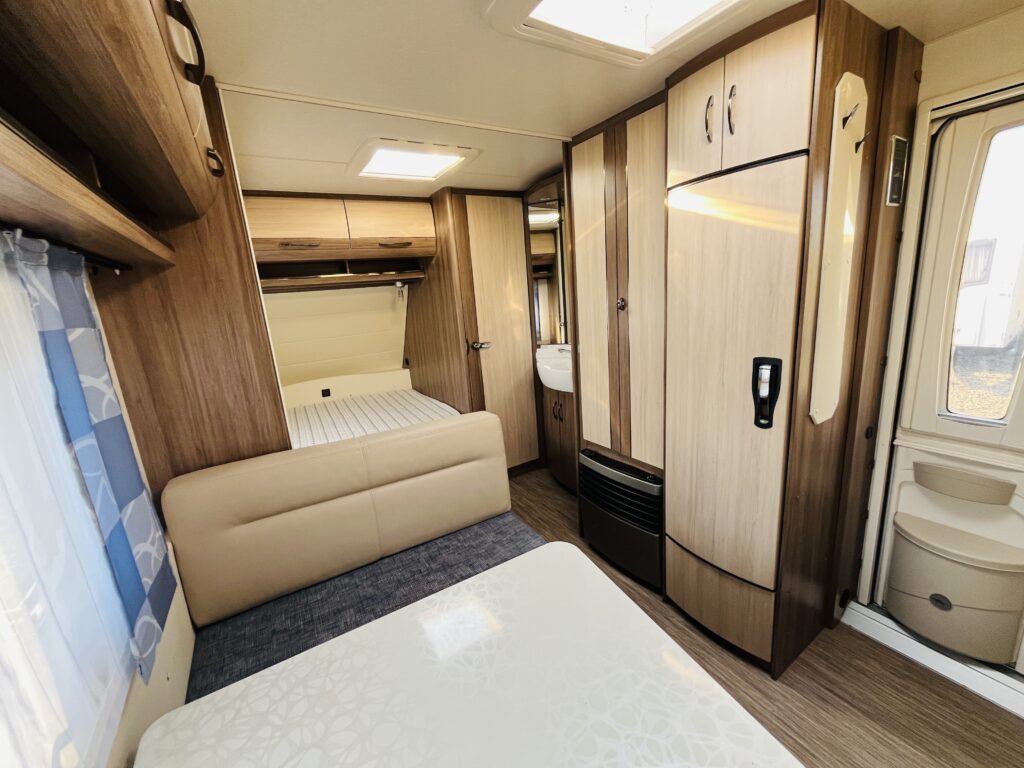 Interiér moderního karavanu s pohodlným uspořádáním a dostatkem úložného prostoru.