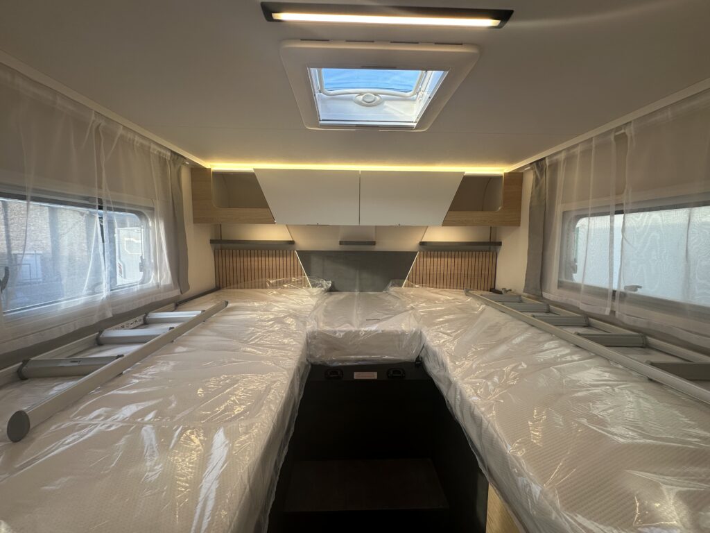 Kuchyňský interiér karavanu s moderním osvětlením a prostorem pokrytým ochrannou fólií.