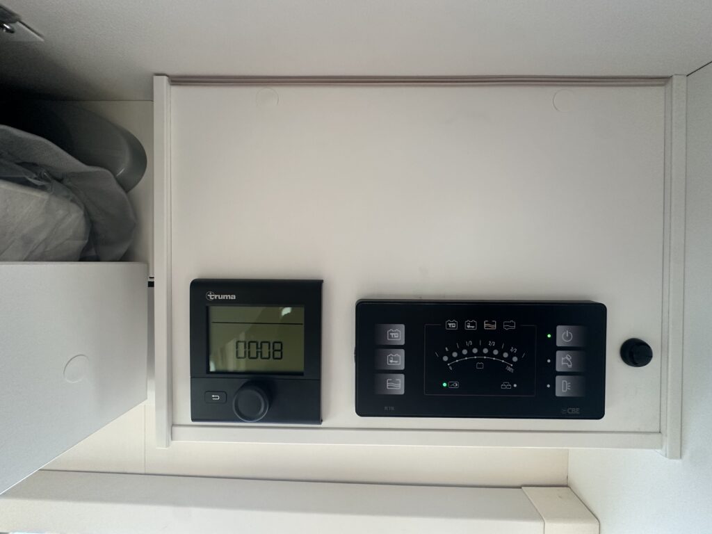 Obrázek ukazuje řídicí panely obytného vozu s ovládáním topení a energetických zdrojů.