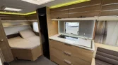 Moderní karavan s prostorným interiérem, kuchyňským koutem a pohodlnou ložnicí. Ideální pro pohodové cestování.
